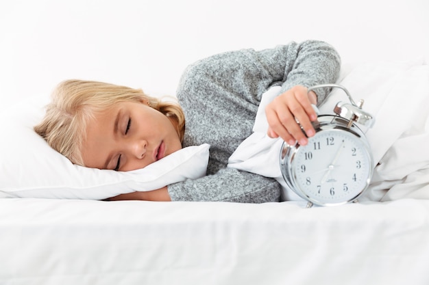 Free photo close-up portrait of sleeping kid holding alarm clock