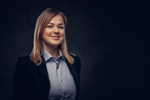 Free photo close-up portrait of a smiling blonde businesswoman formal dressed. isolated on a dark textured background.