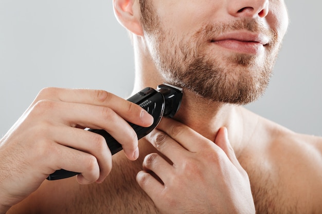 Close up portrait of a smiling man shaving his beard