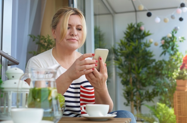 Close up portrait of woman drinking coffee on the balcony