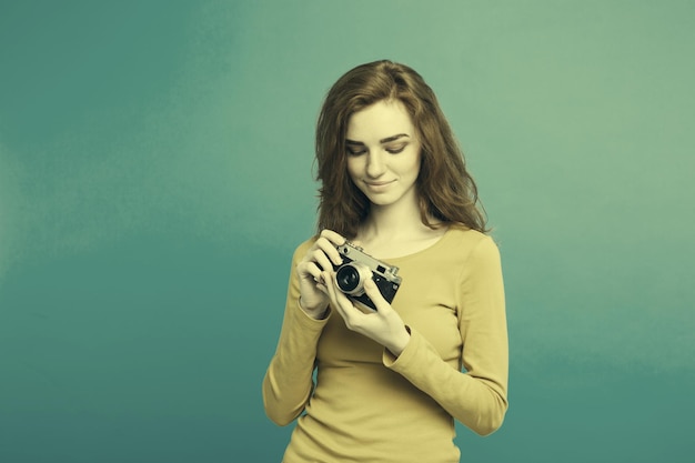 Free photo close up portrait young beautiful attractive ginger girl happy smiling with vintage camera and ready to travel blue pastel background copy space