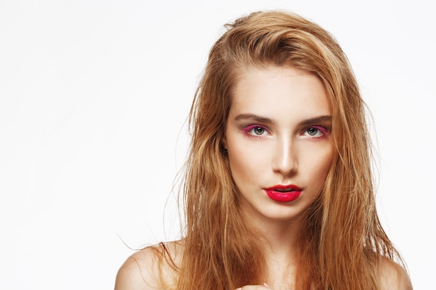 Close-up portrait of young beautiful confident thoughtful girl with bright make up. white wall. Isolated.