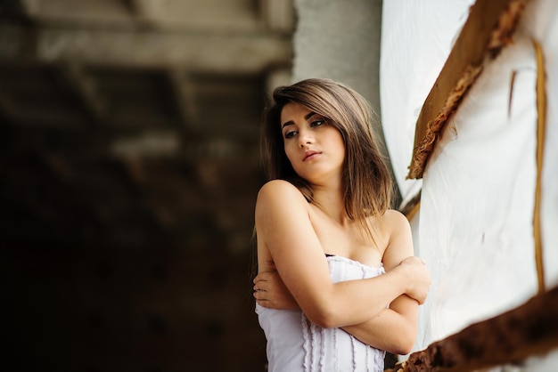 Free photo close up portrait of young cute brunette girl posed on abandoned place