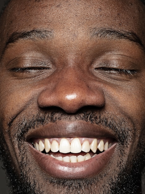 Free Photo close up portrait of young and emotional african-american man. male model with well-kept skin and bright facial expression. concept of human emotions. happy smiling.