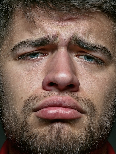 Close up portrait of young and emotional caucasian man. male model with well-kept skin and bright facial expression. Concept of human emotions. Looks sad and upset.