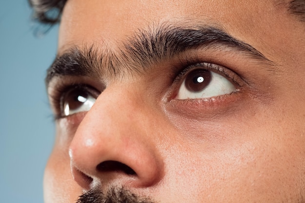 Free Photo close up portrait of young indian man's face with brown eyes looking up or at side. human emotions, facial expression. looking dreaming or hopeful.