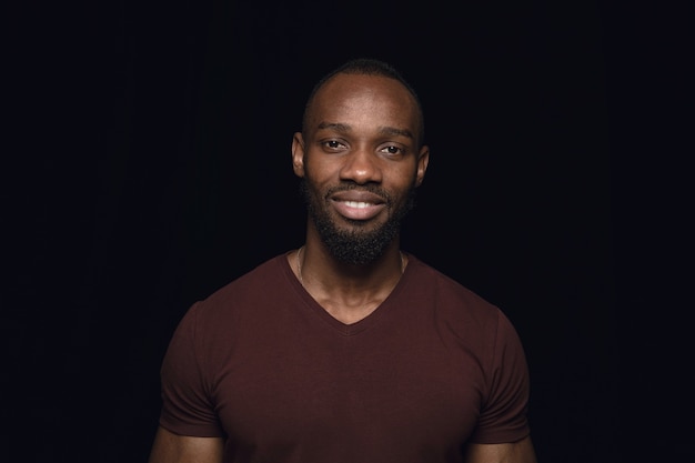 Close up portrait of young man isolated on black studio