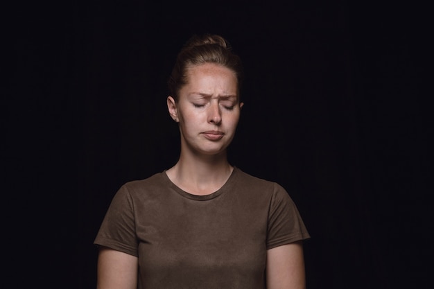 Free photo close up portrait of young woman isolated on black studio wall