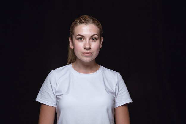 Close up portrait of young woman isolated on black studio