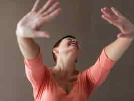 Free photo close-up positive senior woman raising hands