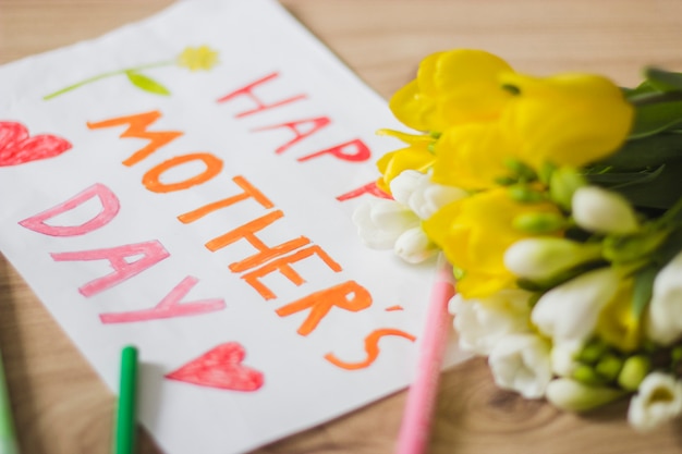 Free photo close-up of poster for mother's day and yellow flowers