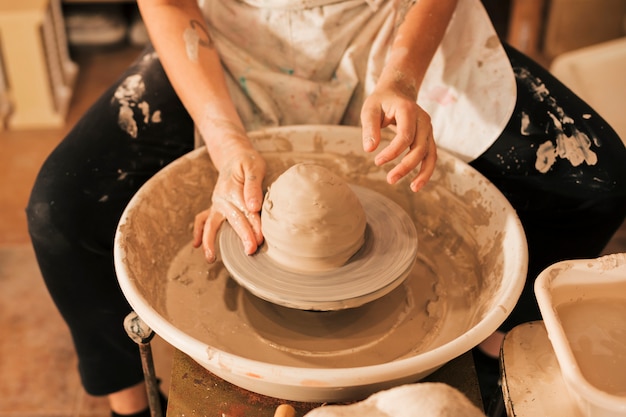 Free Photo close-up of potter's hands working on pottery wheel