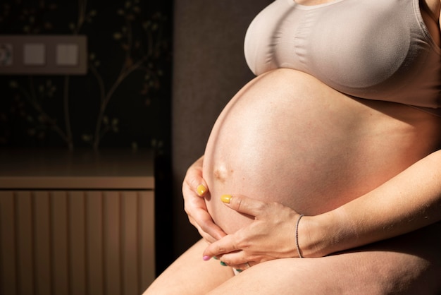 Close up pregnant woman holding tummy