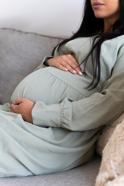 Close up pregnant woman sitting on couch