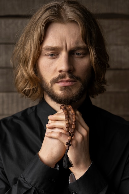 Close up priest holding rosary