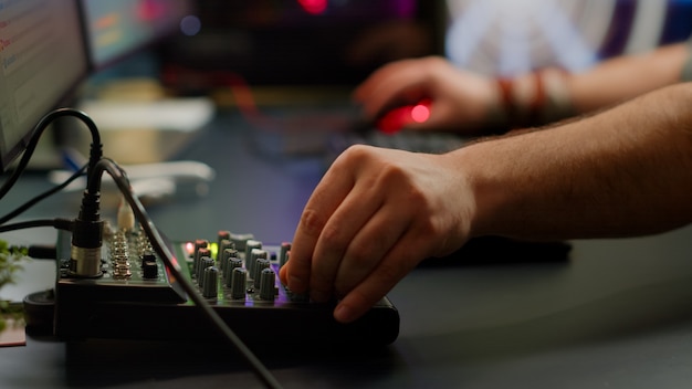 Close up of professional keyboard with RGB lighting streaming at chat. Player using powerful gaming computer in home studio of esport video game typing at keypad playing space shooter videogame.