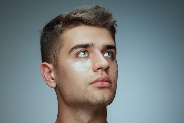 Free photo close-up profile portrait of young man isolated on grey studio