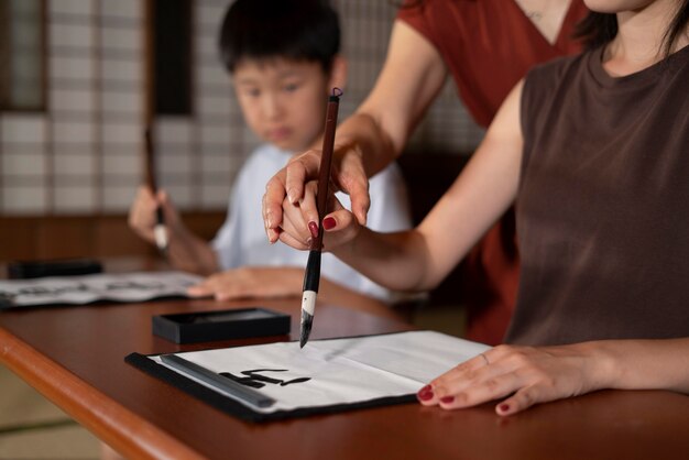 Close up on pupils doing japanese calligraphy, called shodo