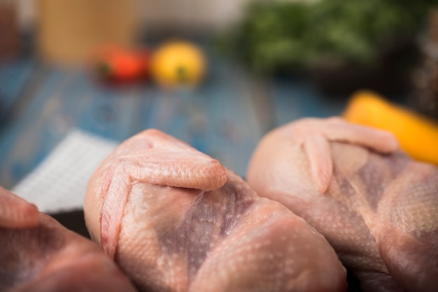 Free photo close-up raw chicken on wooden board with ingredients