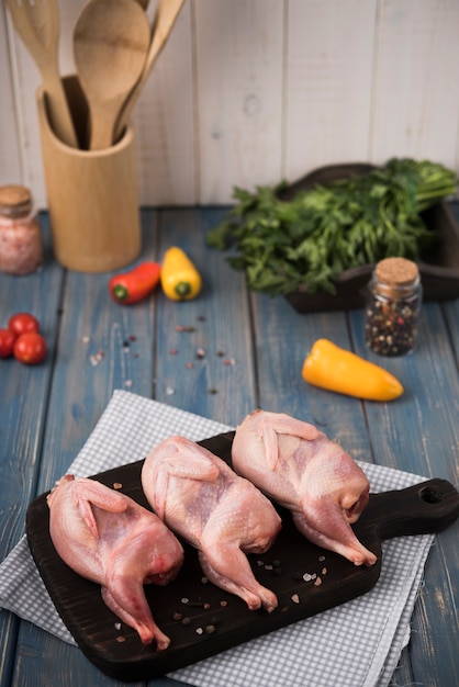 Close-up raw chicken on wooden board with peppers