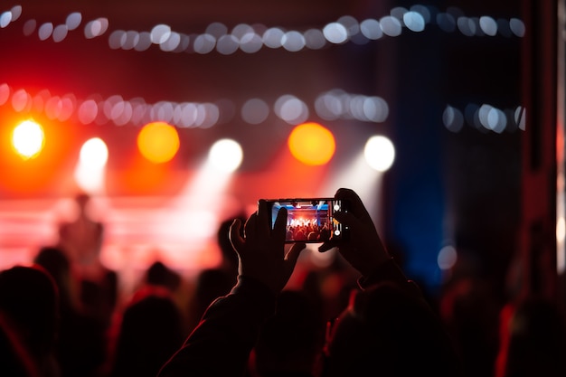 Free Photo close up of recording video with smartphone during a concert. toned picture