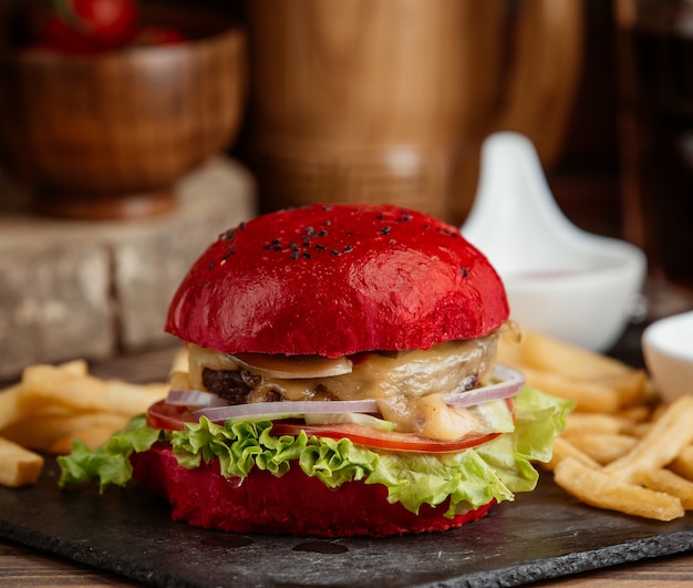 Free photo a close up of red burger with lettuce, onion, melted cheese