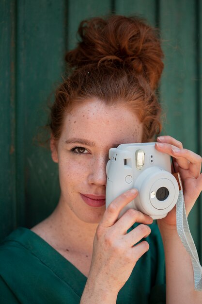 Close-up redhead woman using a vintage camera