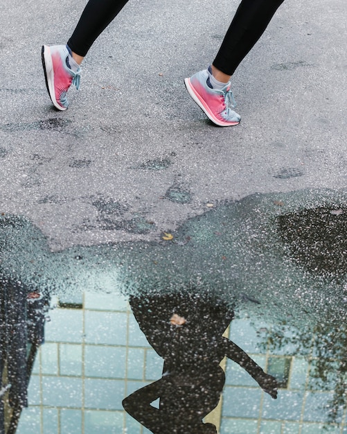 Free Photo close-up of reflection of woman in puddle