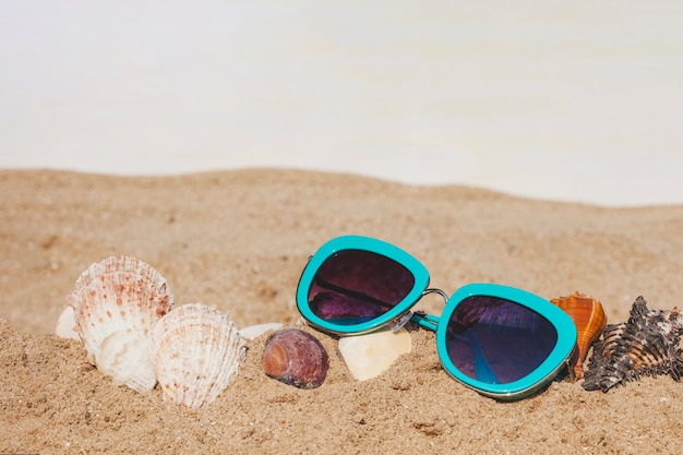 Free photo close-up of sand with sunglasses and seashells