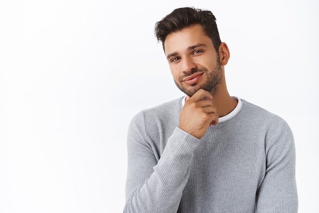 Close-up satisfied handsome bearded guy made his choice, proud or pleased with good decision, rubbing chin smiling in approval, agreement expression, like idea what buy girlfriend for b-day gift