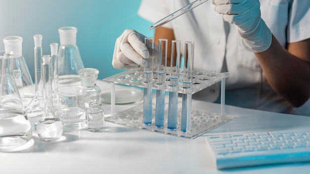 Free photo close-up scientist holding tube and pipette