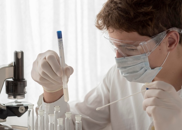 Close-up scientist looking at flask