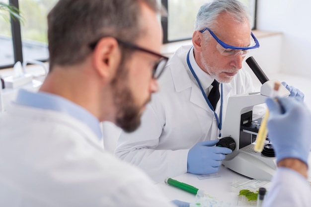 Free photo close up scientist working with microscope