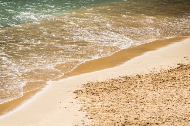 Close-up sea water touching sand at the shore