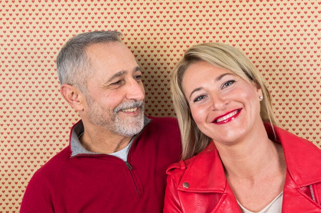 Close-up of senior couple against wall paper