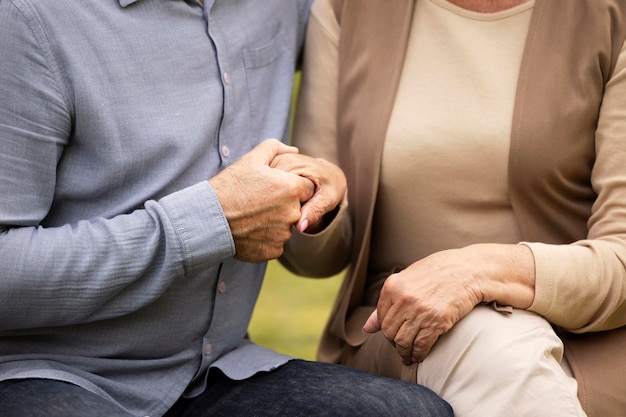 Free photo close up senior couple holding hands