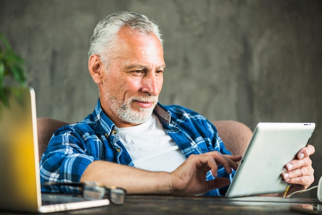 Close-up of senior man using digital tablet