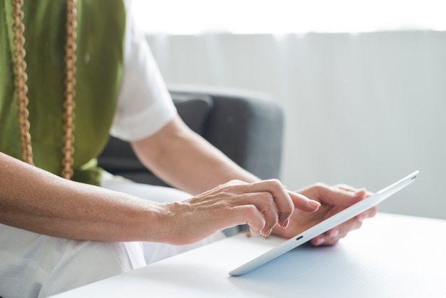 Close-up of senior woman's hand using digital tablet