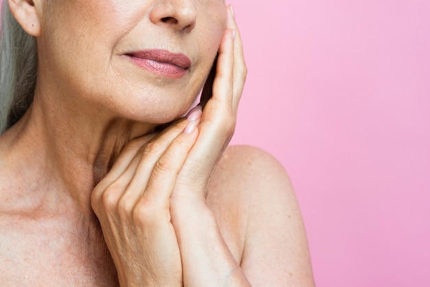 Free photo close-up senior woman with pink background