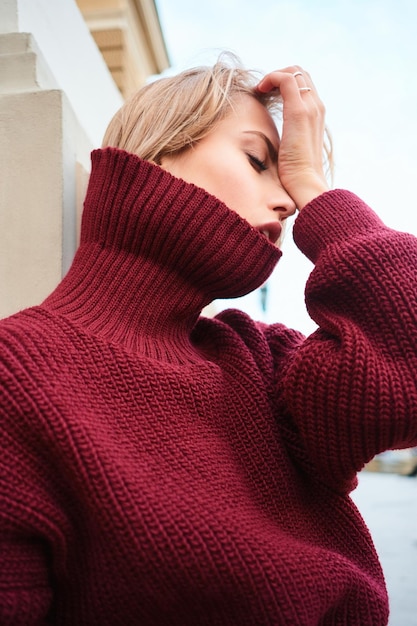 Close up sensual blond girl in knitted sweater emotionally posing outdoor