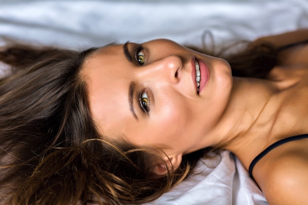 Close up sensual portrait of gorgeous beautiful brunette woman with amazing green olive yes, morning soft light, natural beauty, spa and skincare concept.