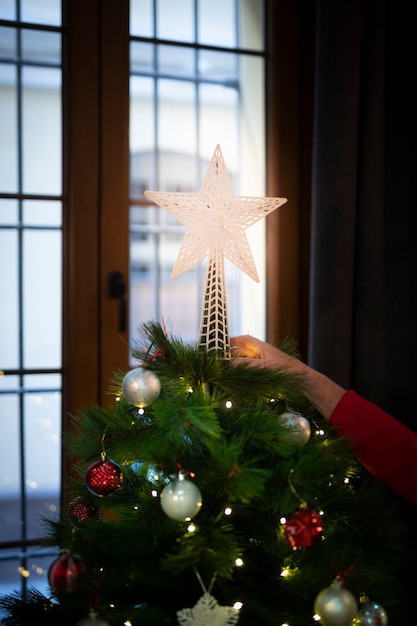 Free Photo close-up shiny christmas star on top of tree