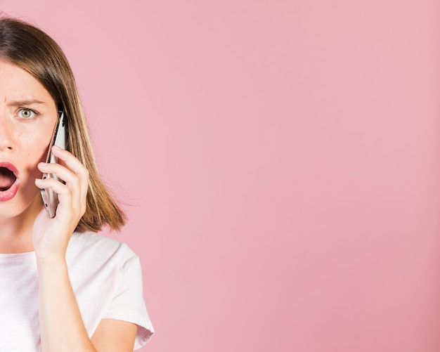 Close up shocked girl being on the phone