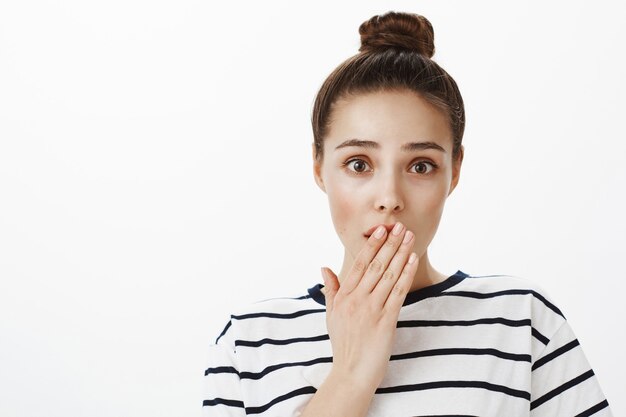 Close-up of shocked girl learn news, gasping and cover mouth astonished