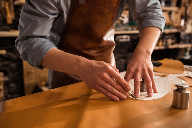 Free photo close up of a shoemaker cutting leather