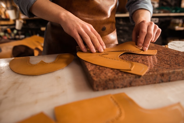 Free photo close up of a shoemaker measuring leather