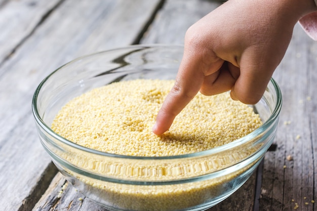 Close up shot of a baby's hand put in a fresh whole amarath grain bowl