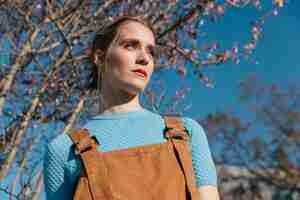 Free photo close up shot female model under blooming tree