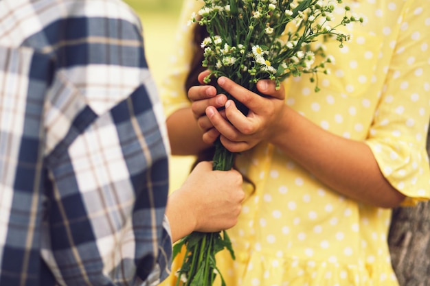 Free photo close up shot of girl recieving flowers from boy