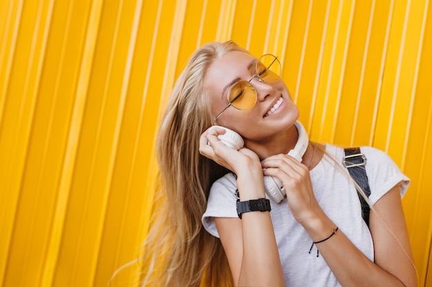 Free photo close-up shot of lovable european woman listening music and laughing.